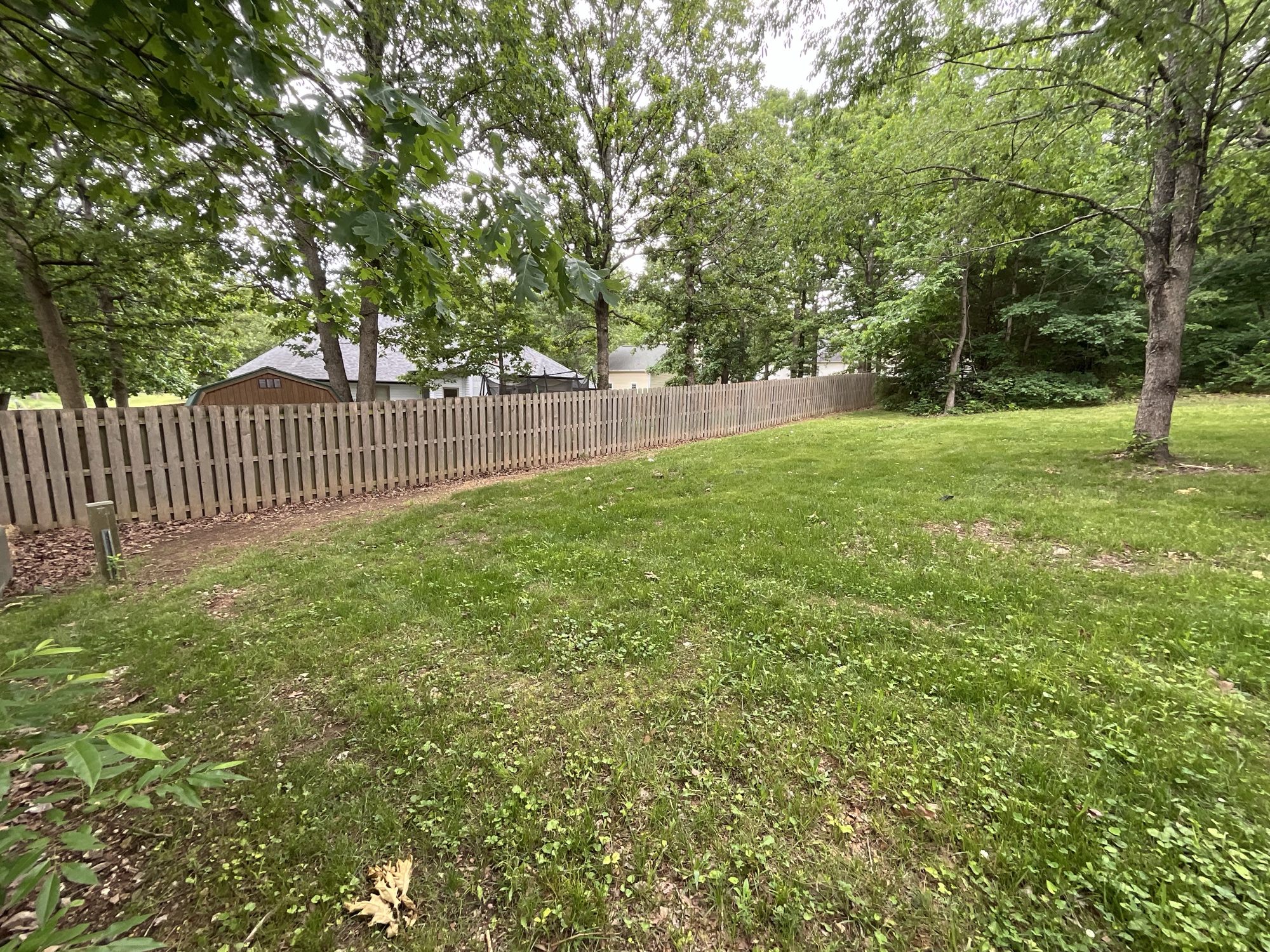 Fence line before — erosion along fence from sloped lot